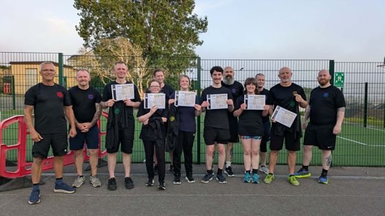 Group holding certificates outdoors